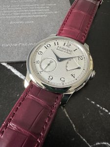 F.P. Journe Chronometre Souverain with silver guilloche dial on a burgundy alligator strap, next to its papers